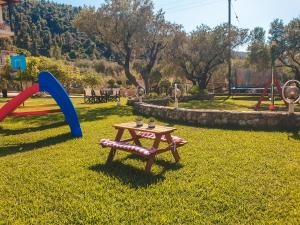 a picnic table and playground equipment in a park at Aroma Studios and Apartments in Vourvourou