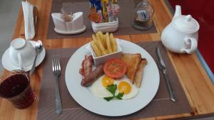 - une assiette de petit-déjeuner avec des œufs au bacon et des frites dans l'établissement SteyMorr Guesthouse, à Maun