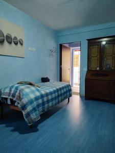 1 dormitorio azul con 1 cama y vestidor en La nuvola 2, en Sagliano Micca