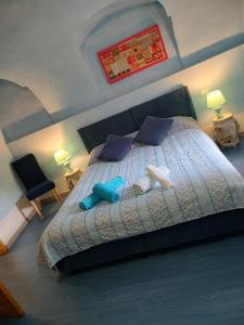 a bedroom with a large bed with blue pillows at La nuvola 2 in Sagliano Micca