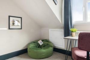a living room with a green ottoman next to a window at Hidden retreat in the heart of the city - 2 Bed Apt in Nottingham