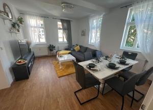 a living room with a table with chairs and a couch at NEST - hell und gemütlich im Herzen Fuldas in Fulda