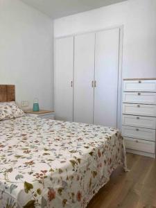 een slaapkamer met een bed en 2 kasten bij Apartament familiar amb vistes al mar! in Salou