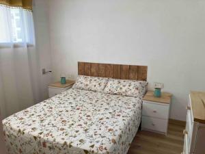 een slaapkamer met een bed en twee nachtkastjes bij Apartament familiar amb vistes al mar! in Salou +12 foto's