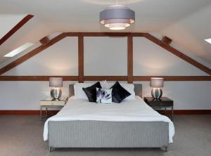 a bedroom with a large white bed with two lamps at Whytings Stud Barn 2 in Horsham