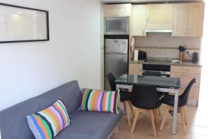 a living room with a couch and a kitchen at Edificio Pujols 3 in Es Pujols