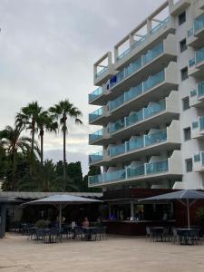 een groot gebouw met tafels en parasols ervoor bij Apartament familiar amb vistes al mar! in Salou