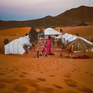 eine Wüste mit weißen Zelten in der Wüste in der Unterkunft Zahra Luxury Desert Camp in Merzouga