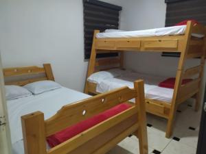 2 łóżka piętrowe w niewielkim pokoju z zapaleniem kręgosłupa, które polega na zapaleniu kręgosłupa w obiekcie Finca El Remanso w mieście Acacias