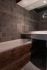 a bathroom with a tub and a sink at IMMODREAMS - Chalet Le Grand Paradis - Avoriaz in Avoriaz