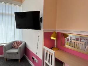 um quarto com uma cadeira e uma televisão na parede em Blackpool Rocks Pleasure Beach em Blackpool