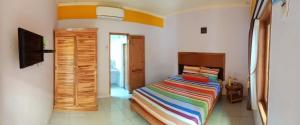 a bedroom with a bed with a colorful striped blanket at Latansa Homestay in Banyuwangi
