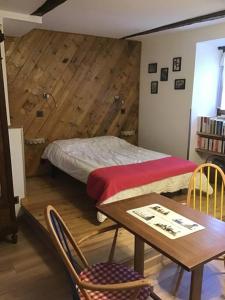 Habitación con cama, mesa y sillas. en Chez Jules, en Saint-Martin-Vésubie