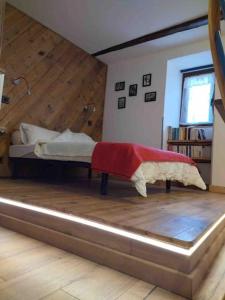 1 dormitorio con 1 cama y suelo de madera en Chez Jules, en Saint-Martin-Vésubie
