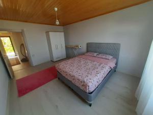 Schlafzimmer mit einem Bett und einem roten Teppich in der Unterkunft Yomra Köy Evi in Yomra