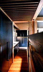 a kitchen with black cabinets and a wooden floor at Apartman Mary Lou, Hotel Ovruc in Štrbské Pleso