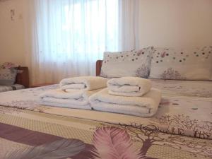 a pile of towels sitting on top of a bed at Λευκό σπίτι in Ksamil