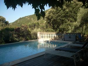 una piscina con due sedie a sdraio accanto di Demeure traditionnelle en pierre avec piscine a Sartène