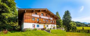 duży drewniany budynek z napisem na nim w obiekcie Ferienhof Millinghof w mieście Leogang +36 zdjęć