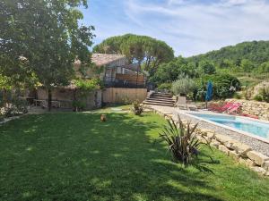 un cortile con piscina e una casa di Gite de charme La Martinelle a La Bégude-de-Mazenc