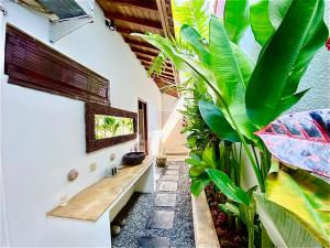 a bathroom with a sink and a large plant at Villa Belharra in Seminyak
