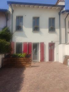 uma casa branca com portas vermelhas e uma entrada de tijolos em La casa di Paolina - Affitti turistici CIR017067-LNI-00070 em Desenzano del Garda