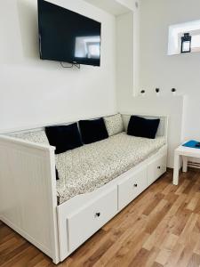 a white couch with a television on a wall at Penzion Nový Svět in Krásno