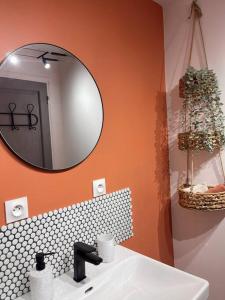 uma casa de banho com um lavatório branco e um espelho. em Maison Opaline em Berck