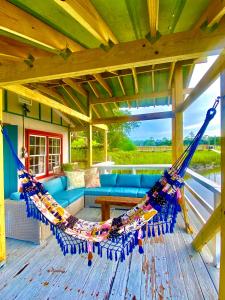 a porch with a hammock and a couch on a deck at Creekside Paradise in Tybee Island