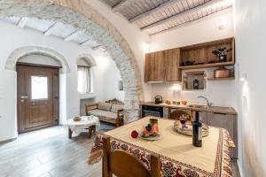 Casa Estiva Apeiranthos Naxos Apartments في ناكسوس تشورا: مطبخ وغرفة معيشة مع طاولة