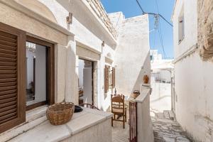 a balcony of a house with a basket on a ledge at Casa Estiva Apeiranthos Naxos Apartments in Naxos Chora