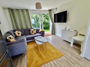 sala de estar con sofá y mesa en Beach Woods Coastal Path chalet en Pembrokeshire