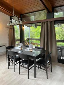 a dining room with a black table and black chairs at Le petit gîte in Vresse-sur-Semois