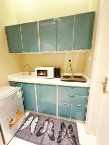 a small kitchen with blue cabinets and butterflies on the floor at Elegant and luxurious one bedroom studio, side entrance 1D in Riyadh