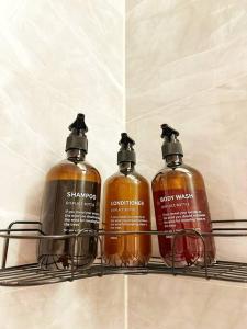three bottles of soap on a shelf in a bathroom at Elegant and luxurious one bedroom studio, side entrance 1D in Riyadh