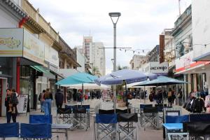 科连特斯WyW PEATONAL JUNIN的城市街道上的一组椅子和遮阳伞