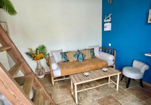 sala de estar con sofá y mesa en Anaélodge piscine privée chauffée 30 degrés, en Le Tampon