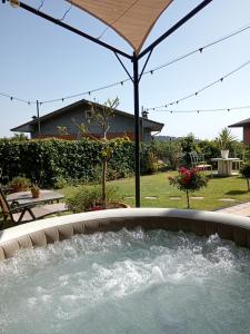 a hot tub in a patio with an umbrella at Good Morning Etna in Bronte