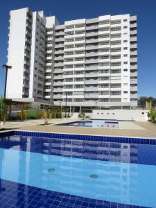 une piscine en face d'un grand bâtiment dans l'établissement Recanto do Bosque Apartamentos para Temporada, à Caldas Novas
