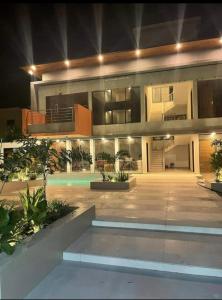 ein großes Haus mit Swimmingpool in der Nacht in der Unterkunft Benteh Aqua View in Banjul