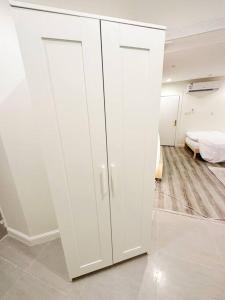 une armoire blanche dans une chambre avec un lit dans l'établissement ستوديو أنيق ، مدخل جانبي 101b, à Riyad