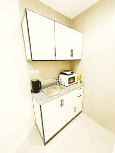 Il comprend une petite cuisine équipée d'un évier et d'un four micro-ondes. dans l'établissement ستوديو أنيق ، مدخل جانبي 101b, à Riyad
