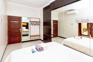 a hotel room with two beds and a mirror at Surfrider Yogyakarta in Yogyakarta