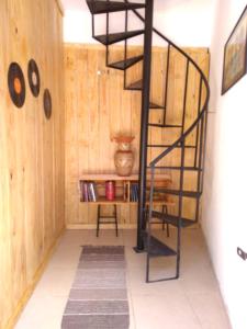 a spiral staircase in a room with a shelf at Loft da Montanha (A 8min do centro) in Nova Friburgo