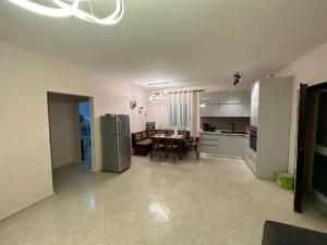a kitchen and dining room with a table and refrigerator at Relax Pine Villa Residence in Golem