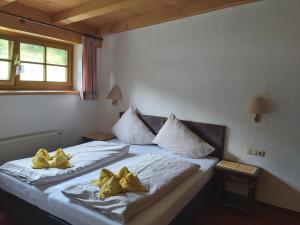 um quarto com 2 camas com almofadas amarelas em Ferienhof Millinghof em Leogang