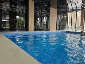a large swimming pool with blue water in a building at Baltic Harmony - Easy-Rent Apartments in Pobierowo