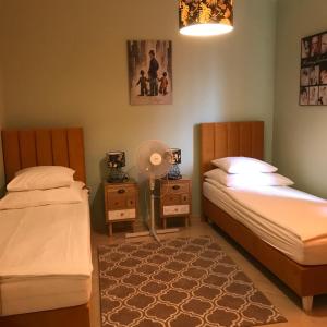 a bedroom with two beds and a lamp and a fan at Noclegi VIVA in Mszczonów