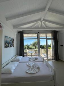 a bedroom with two beds and a balcony at Essos Villas in Dhërmi