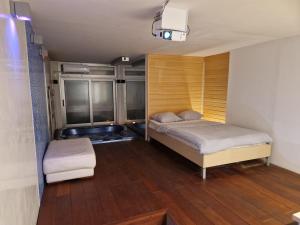 um pequeno quarto com 2 camas e um banco em Jacuzzi Vaki Apartment em Belgrado